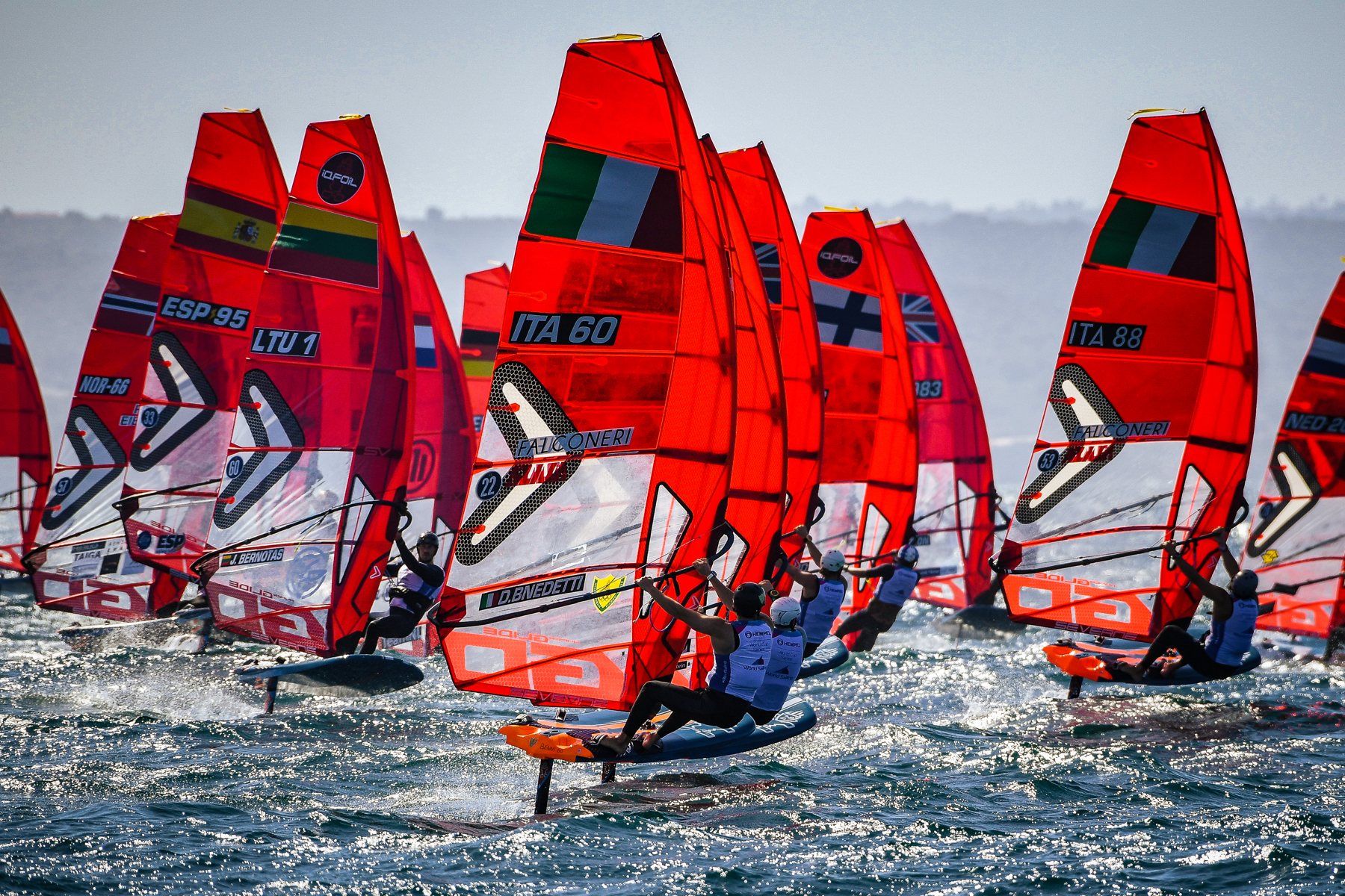 Flotta di windsurf iQFOiL con vele rosse in regata