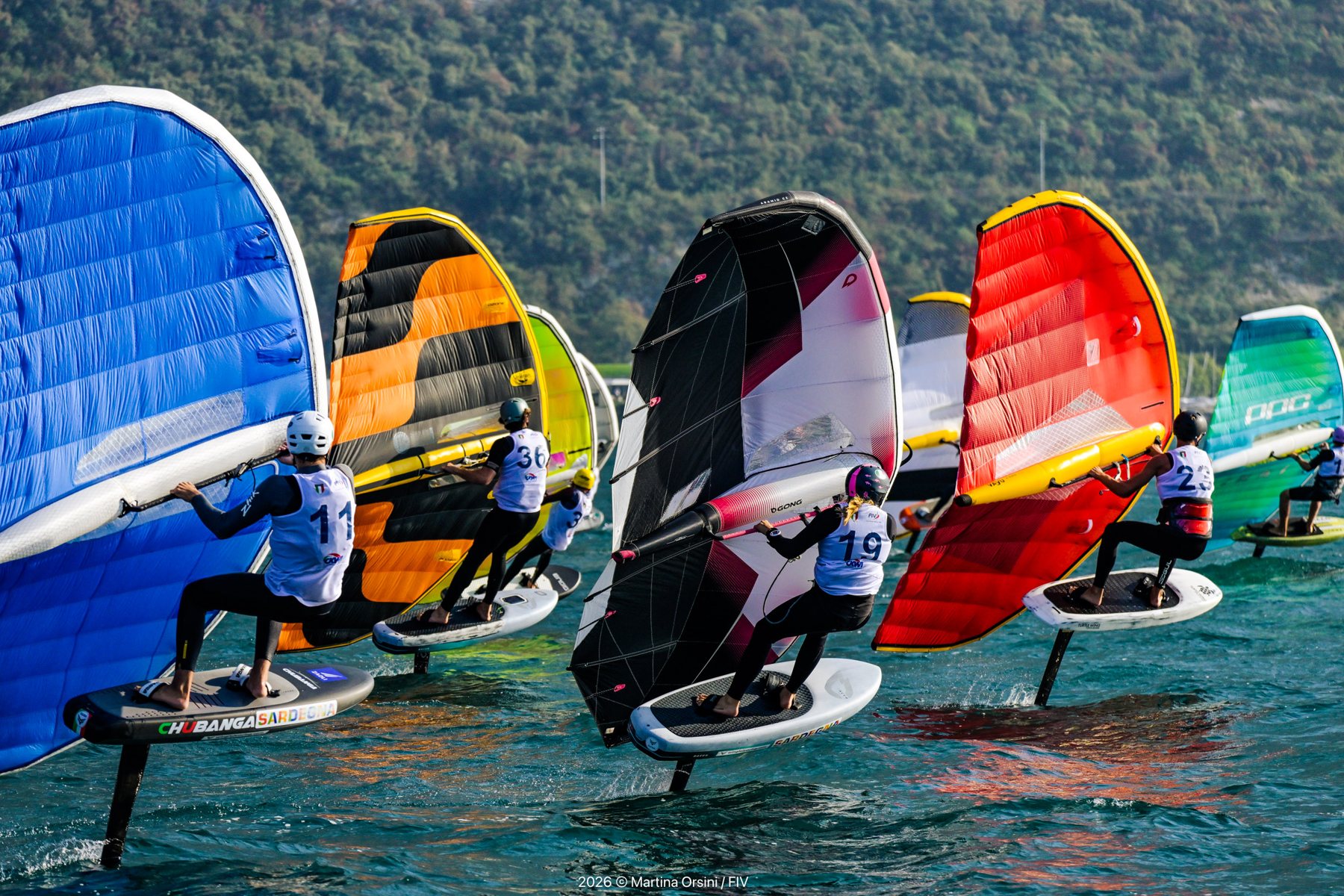 Atleti di wing foil con ali colorate in volo su foil